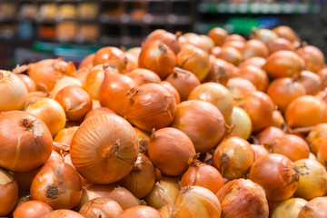 Fresh yellow onions as a background. Vegetable store. Yellow onion lies in a box in a store for sale
