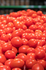Vegetables are full of vitamins. Fresh and ripe tomatoes in a basket on a supermarket shelf. Ripe tomatoes in a supermarket. vertical photo