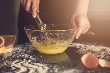 girl preparing cookies in the shape of a heart for the holiday Valentine's Day at home, in a small bakery, family business, authentic, hobby, mood, cozy. Care and love