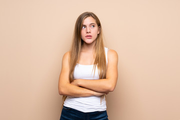 Obraz premium Teenager blonde girl over isolated background with confuse face expression