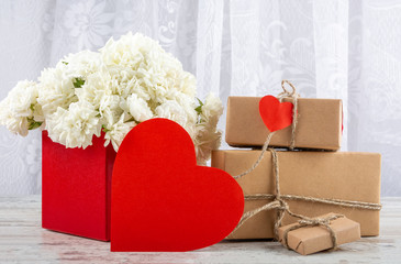 Bouquet of white roses in a red box and a symbol of the heart for the inscription. Valentine's day, wedding, declaration of love. Space for text, front view, copy space.