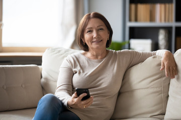 Obraz premium Portrait of happy senior woman using cellphone at home