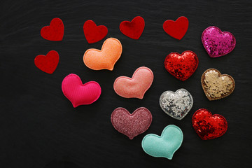 Fototapeta premium Valentines day concept. red glitter hearts over black background. Flat lay composition