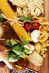 Pasta, vegetables, herbs and spices for Italian food on rustic table
