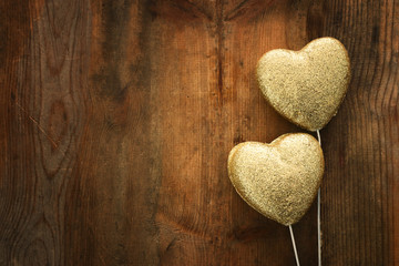 Valentines day concept. gold glitter hearts over wooden background. Flat lay composition