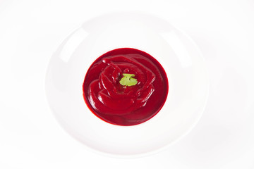 Beetroot cream soup decorated with coriander leaf