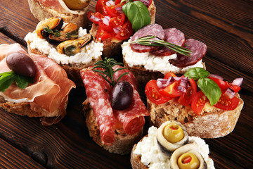 Appetizers table with italian antipasti snacks and wine in glasses. Brushetta or authentic traditional spanish tapas set, cheese variety