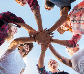 close up of group of adults with their hands in the middle - union and team workers - ground view