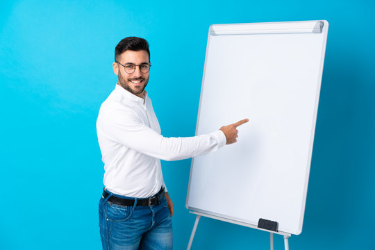 Businessman giving a presentation on white board giving a presentation on white board and writing in it