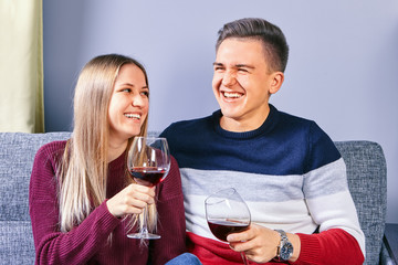 Young man and woman drink wine and laugh.
