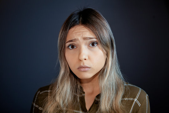 Upset look of a young woman watching television.