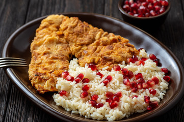 Turkey schnitzel, served with rice and pomegranate seeds.
