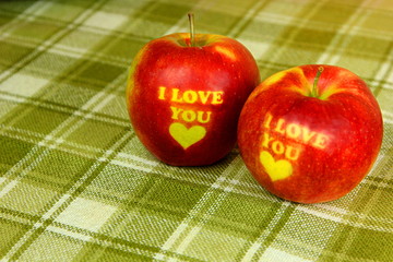 Two Red Apple with text I LOVE YOU on green backaground. I love you apple. Apple for Valentine's Day