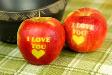 Two Red Apple with text I LOVE YOU on green backaground. I love you apple. Apple for Valentine's Day