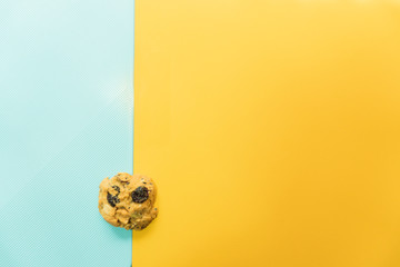 Cookies that contain a mixture of almonds and raisins. Placed on a yellow and blue background with copy space.pastle style