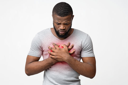 Sad young man suffering from acute pain in chest