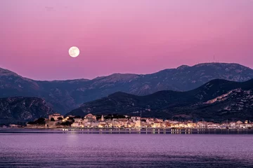 Fotobehang Fluor Roze Volle maan komt op boven St Florent op Corsica  © Jon Ingall