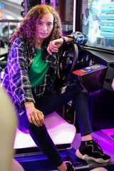Fototapeta na wymiar Girl behind the wheel of a driving simulator machine
