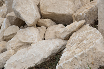 Big pile of large sand stones laying on the ground of construction site.