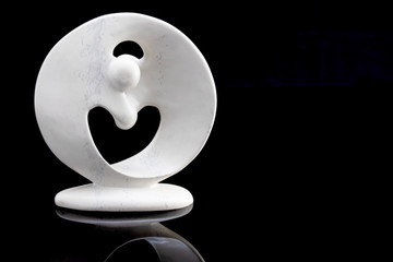 Kreis der Liebe aus Keramik mit Herz und Spiegelung isoliert auf schwarzem Hintergrund