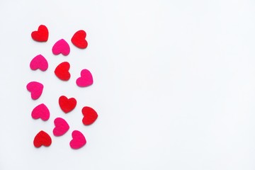 Red and pink felt hearts on a white background. Valentine's day symbol, holiday concept. Top view with copy space for text.