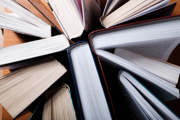 Books standing on a wooden table, top view