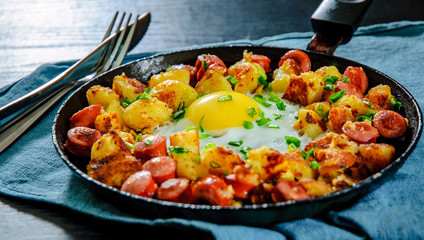 fried egg with sausage and potato in a frying pan - obrazy, fototapety, plakaty