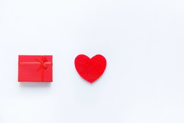 Red felt heart and gift box on a white background. Valentine's day symbol, holiday concept, minimal style. Top view with copy space for text.