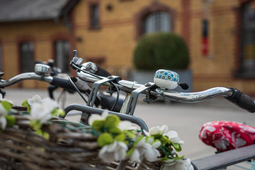 Bunte Fahrradklingel mit Blumenbastkorb im Vordergrund