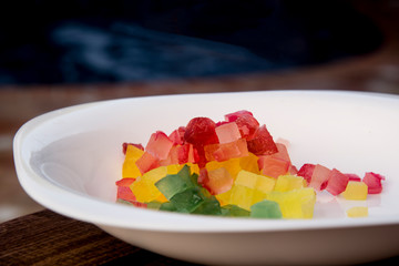 cut candied fruits on white tray and abstract background