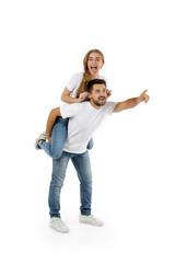 man carrying young woman on his back. boyfriend giving piggyback to girlfriend on white background