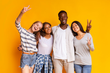 Carefree international students having fun over yellow background - Powered by Adobe