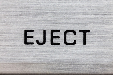 Macro close up photograph of vintage tape machine eject button detail.  