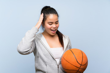 Young Asian girl playing basketball over isolated background