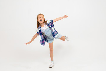 young attractive charming caucasian girl jumping in casual clothes on a light blue studio background