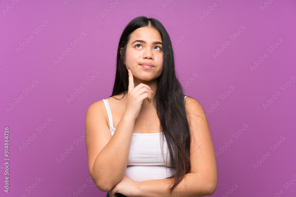 Poster Young teenager Asian girl over isolated purple background thinking an idea