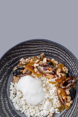Cottage cheese served with sour cream and a mix of dried fruits and nuts