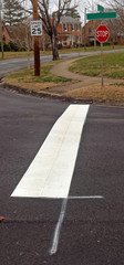 Newly installed white line strip for stop sign on neighborhood street.
