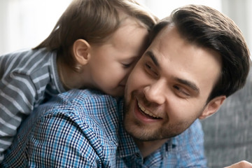 Happy young father and little son playing at home