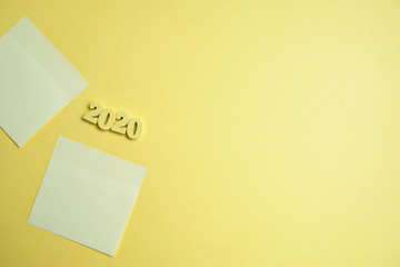 The figures are wooded by 2020 next to stickers on a yellow background. Close up. Top view. Copy...