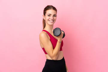 Young sport woman over isolated pink background making weightlifting