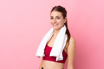 Fototapeta na wymiar Young sport woman over isolated pink background with sport towel