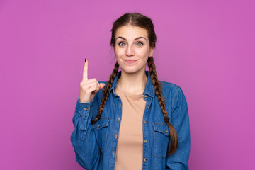 Young woman over isolated purple background pointing with the index finger a great idea