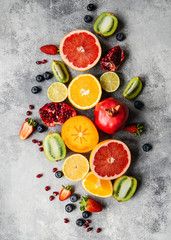 Multicolored seasonal healthy natural fruit composition with persimmon, blueberries, orange, kiwi, strawberries, grapefruit, pomegranate, orange slices.