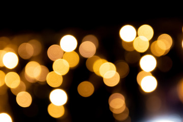 Fototapeta premium Festlicher Hintergrund mit goldenem Bokeh und schöner Unschärfe von weihnachtlicher Beleuchtung als leuchtender Hintergrund für Einladungskarten und Party-Festlichkeiten