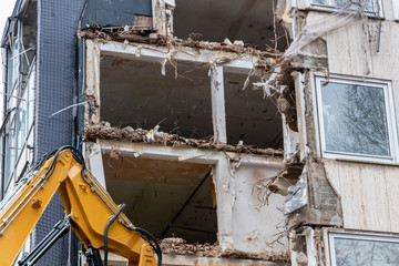 Abriss eines alten maroden Gebäudekomplexes per Abrissbagger schafft Platz für neue Architektur in urbanen Lebensräumen zur Stadtentwicklung nach Erdbeben mit Einsturzgefahr