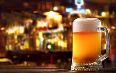 cold mug of beer in a bar on wooden table