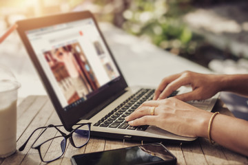Women using laptops searching for clothing online.