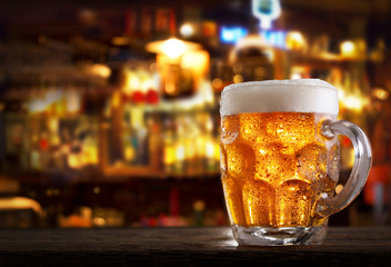 cold mug of beer in a bar on wooden table