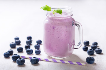 glass jar of blueberry smoothie with fresh berries